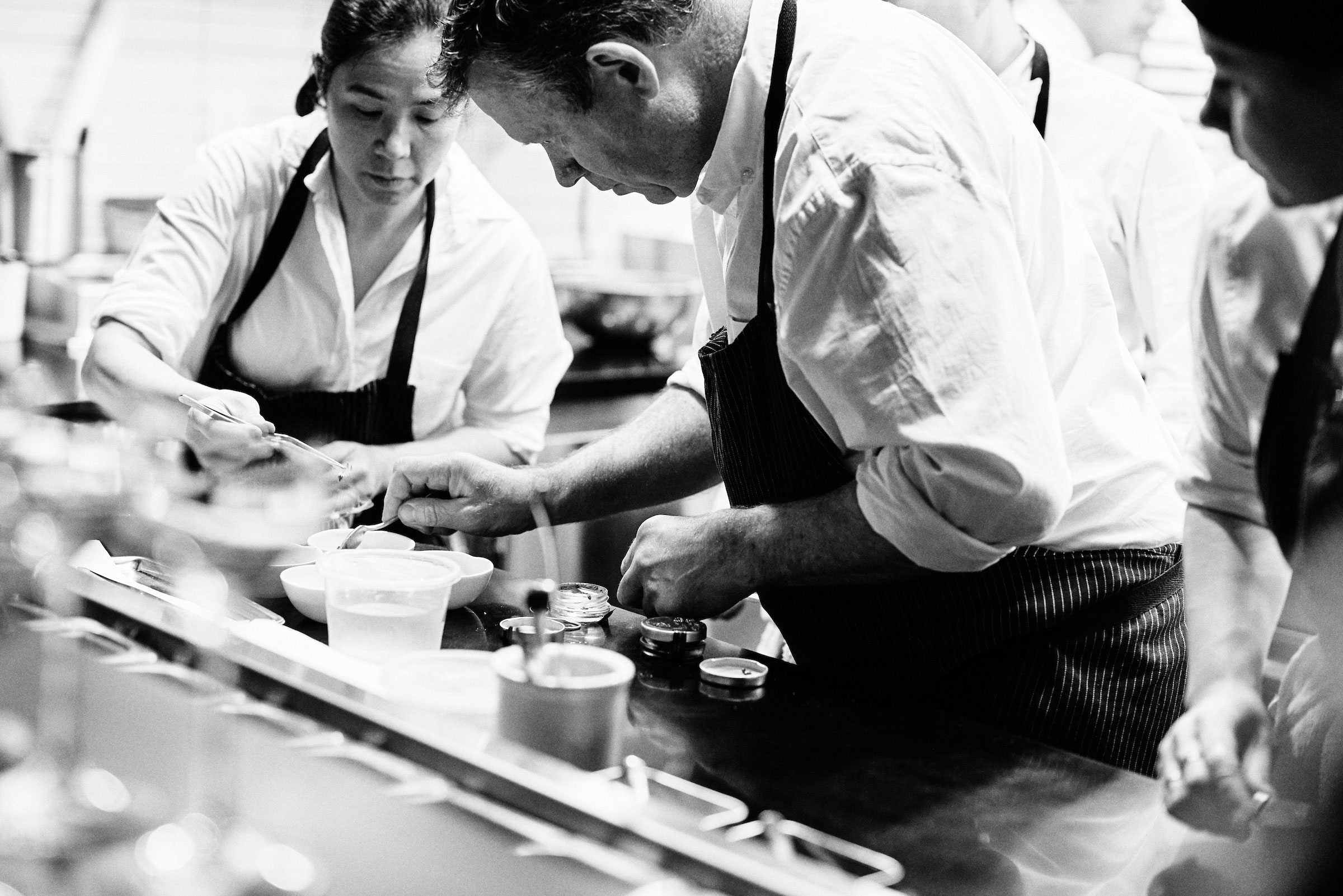 chef walter and chef margarita assembling dishes at the pass