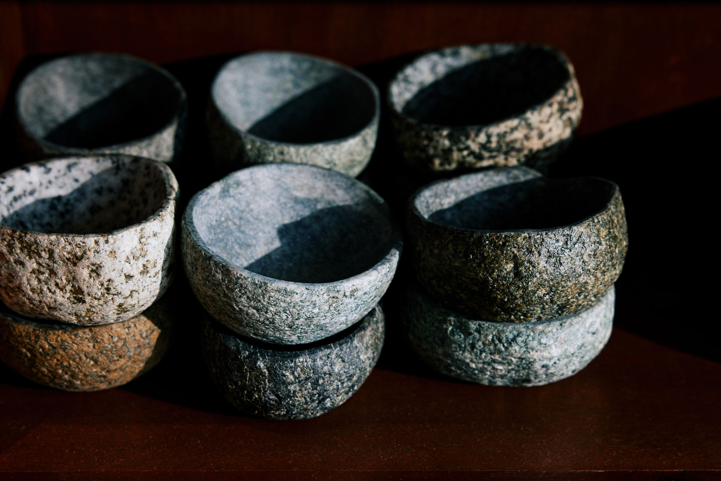 stacks of rustic stone bowls arranged in a row